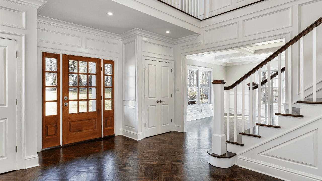 Traditional style home interior with rustic front door and sleek white interior closet doors.